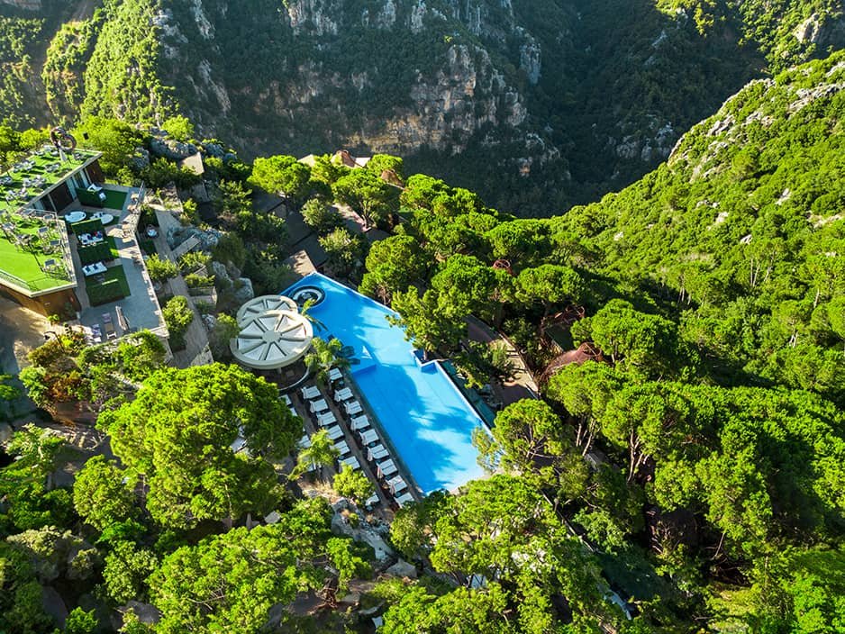 Infinity pool at scappa resort with mountain view surrounded by nature and greenery
