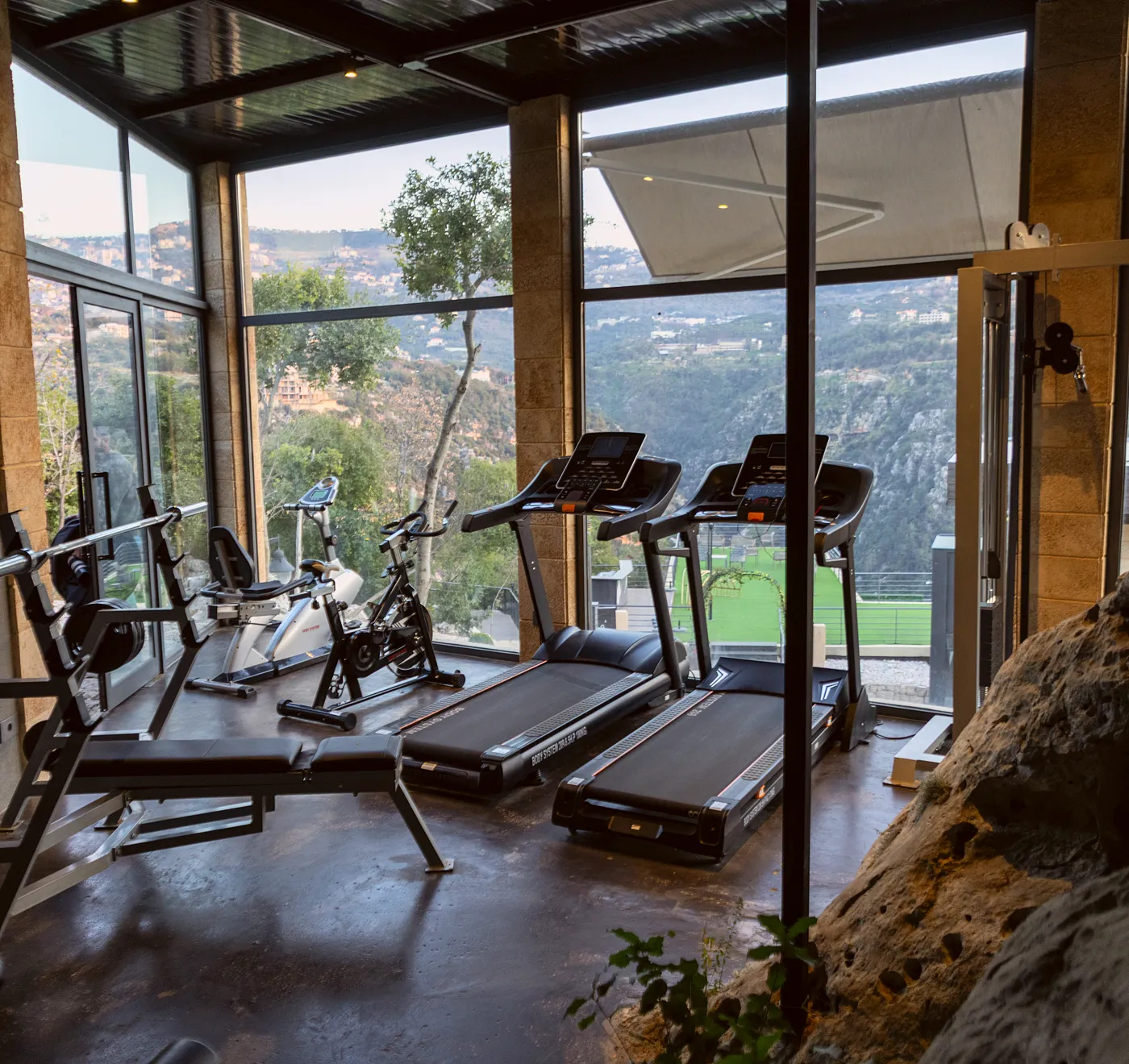 Scappa gym with treadmills, the natural rock wall and the valley view