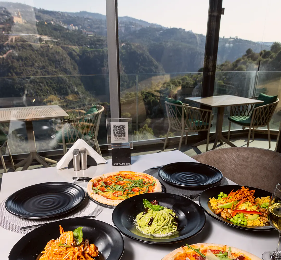 Pizzas, pasta and a fajita bowl on a Scappa restaurant table with the valley view